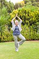 Mature woman doing her streches in the garden