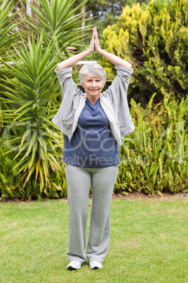 Mature woman doing her streches in the garden