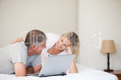 Lovely couple looking at their laptop