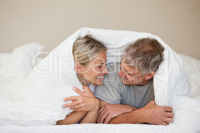 Couple lying down in their bed at home