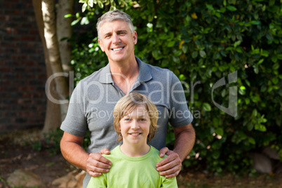 Father and his son looking at the camera in the garden