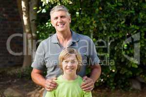 Father and his son looking at the camera in the garden
