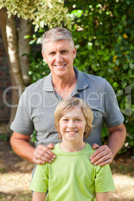 Father and his son looking at the camera in the garden