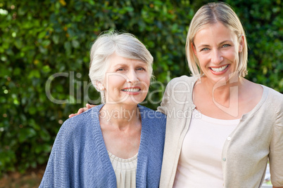 Mother with her daughter looking at the camera in the garden