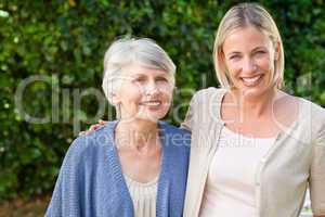 Mother with her daughter looking at the camera in the garden