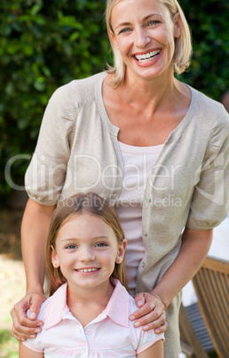 Mother with her daughter looking at the camera in the garden