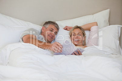 Couple reading a book in their bed