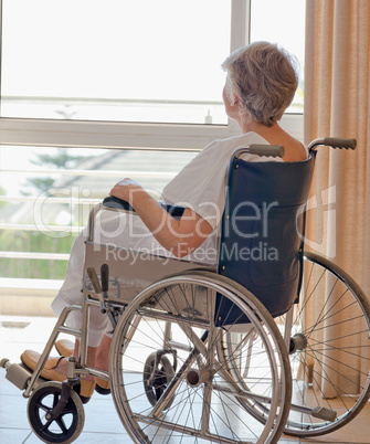 Senior woman in her wheelchair looking out the window