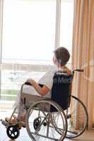 Senior woman in her wheelchair looking out the window