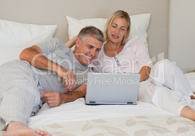 Lovely couple looking at their laptop