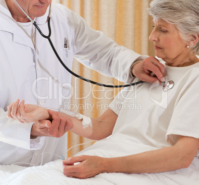 Senior doctor taking the heartbeat of his patient