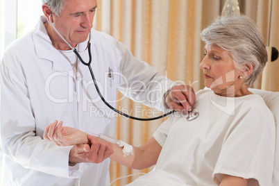 Senior doctor taking the heartbeat of his patient