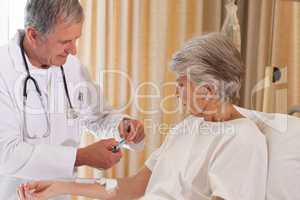 Doctor putting a drip on the arm of his patient