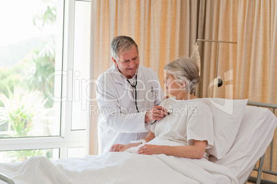 Senior doctor taking the heartbeat of his patient