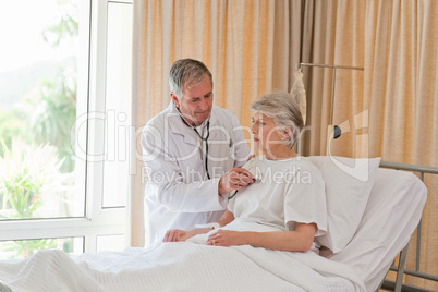 Senior doctor taking the heartbeat of his patient