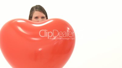 Frau lässt Herz Luftballon fliegen