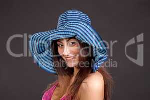 Pretty young smiling girl in hat on dark