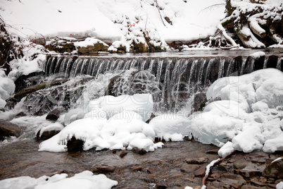 Winter waterfall in the snowy forest