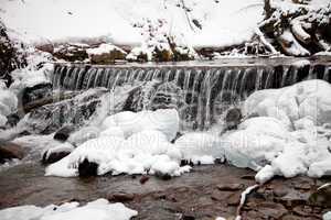 Winter waterfall in the snowy forest