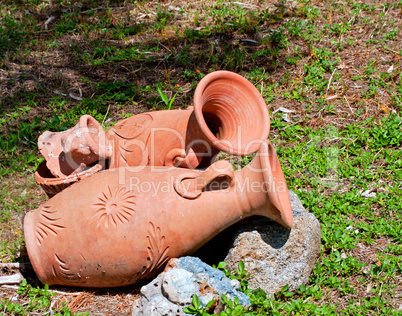 Greek amphoras lying on green grass