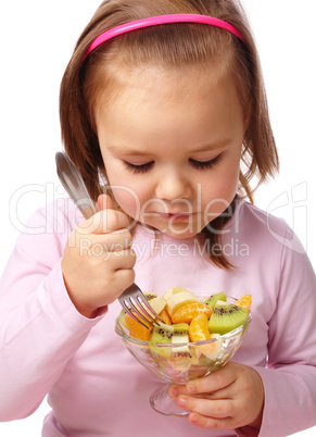 Little girl eats fruit salad