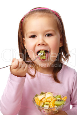 Little girl eats fruit salad