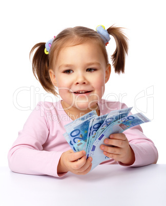 Little girl with few paper euro banknotes