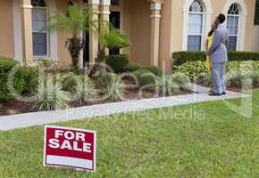 African American Couple Beside House For Sale Sign