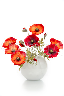 The image of a bouquet of artificial poppies in a vase, isolated