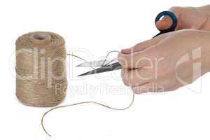 The image of a hand with the scissors cutting a rope, isolated,