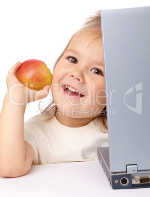 Cute little girl with laptop and apple
