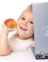 Cute little girl with laptop and apple