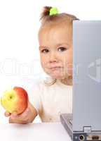 Cute little girl with laptop and apple