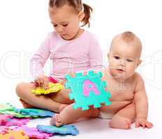 Little boy and girl are playing with alphabet