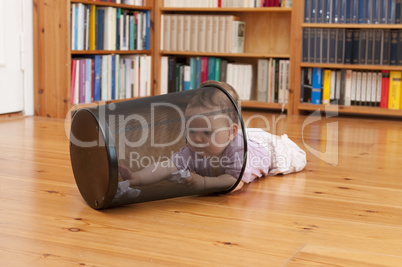 Baby playing with waste basket