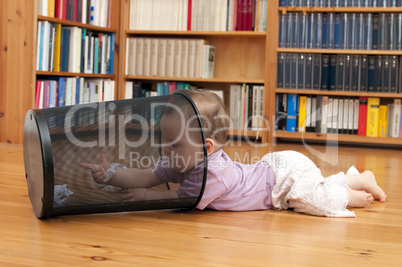 Baby playing with waste basket