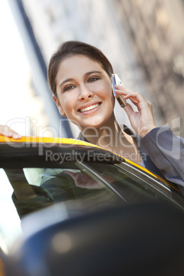 Young Woman Talking on Cell Phone By Yellow Taxi