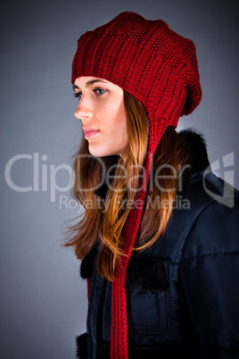 Portrait of the young girl in a winter cap on the dark