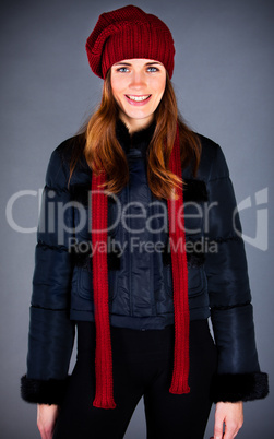 Portrait of the young girl in a winter cap on the dark