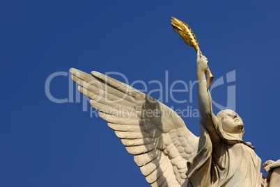 Skulptur mit goldener Feder in der Hand