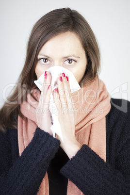 Frau putzt die Nase mit einem Taschentuch