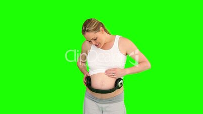 Bauch einer Schwangeren mit Kopfhörern
