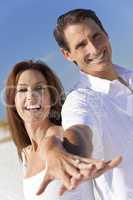 Attractive Couple Laughing Holding Hands on A Beach