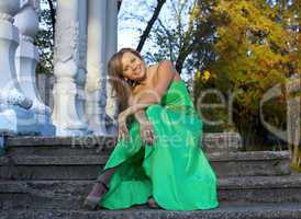 Beauty woman in green clothes sit on stair