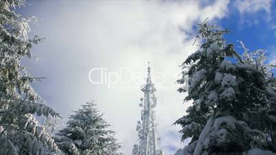 Cellular tower in snow on a blue sky background time lapse