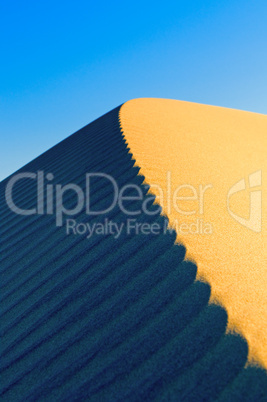 sand dunes over blue sky