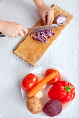 Woman cutting onion on white