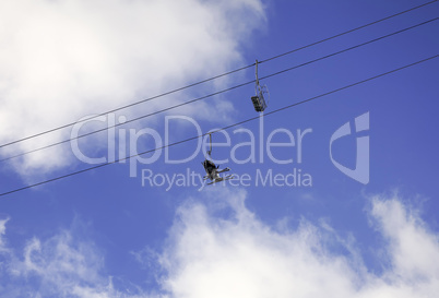 Pair of skiers sitting in chairs on ski lift