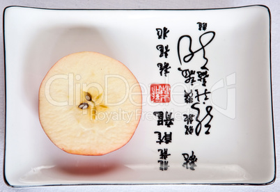Apple slice on japanese dish with hieroglyphs