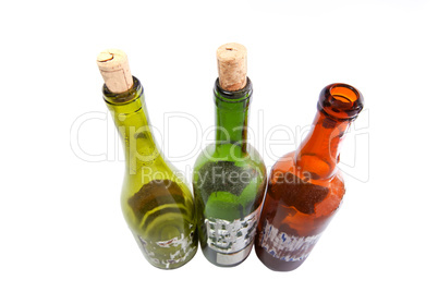 Three dusty wine bottles isolated on white